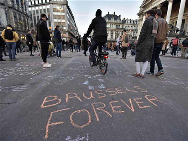 A writing on the asphalt reads "Brussels forever" at the place de la Bourse in the center of Brussels, where people write hundreds of messages on the ground to remember the victims of todays attack, Tuesday, March 22, 2016. Bombs exploded at the Brussels airport and one of the city's metro stations Tuesday, killing and wounding scores of people, as a European capital was again locked down amid heightened security threats. (AP Photo/Martin Meissner)