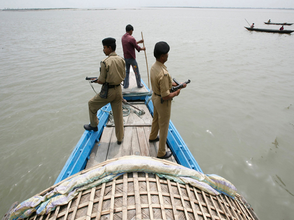 Indian Border Security Force (BSF) soldiers patrol on a boat in the waters of river Brahmaputra near the border with Bangladesh ahead of second phase polls, at Dhubri, about 280 km (174 miles) west from Guwahati, the major city of India's northeastern state of Assam April 22, 2009. India will hold a general election between April 16 and May 13. REUTERS/Rupak De Chowdhuri (INDIA MILITARY POLITICS ELECTIONS) - RTXE9BK